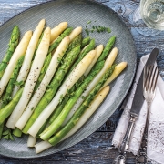 Boiled green and white Asparagus as top view on a plate